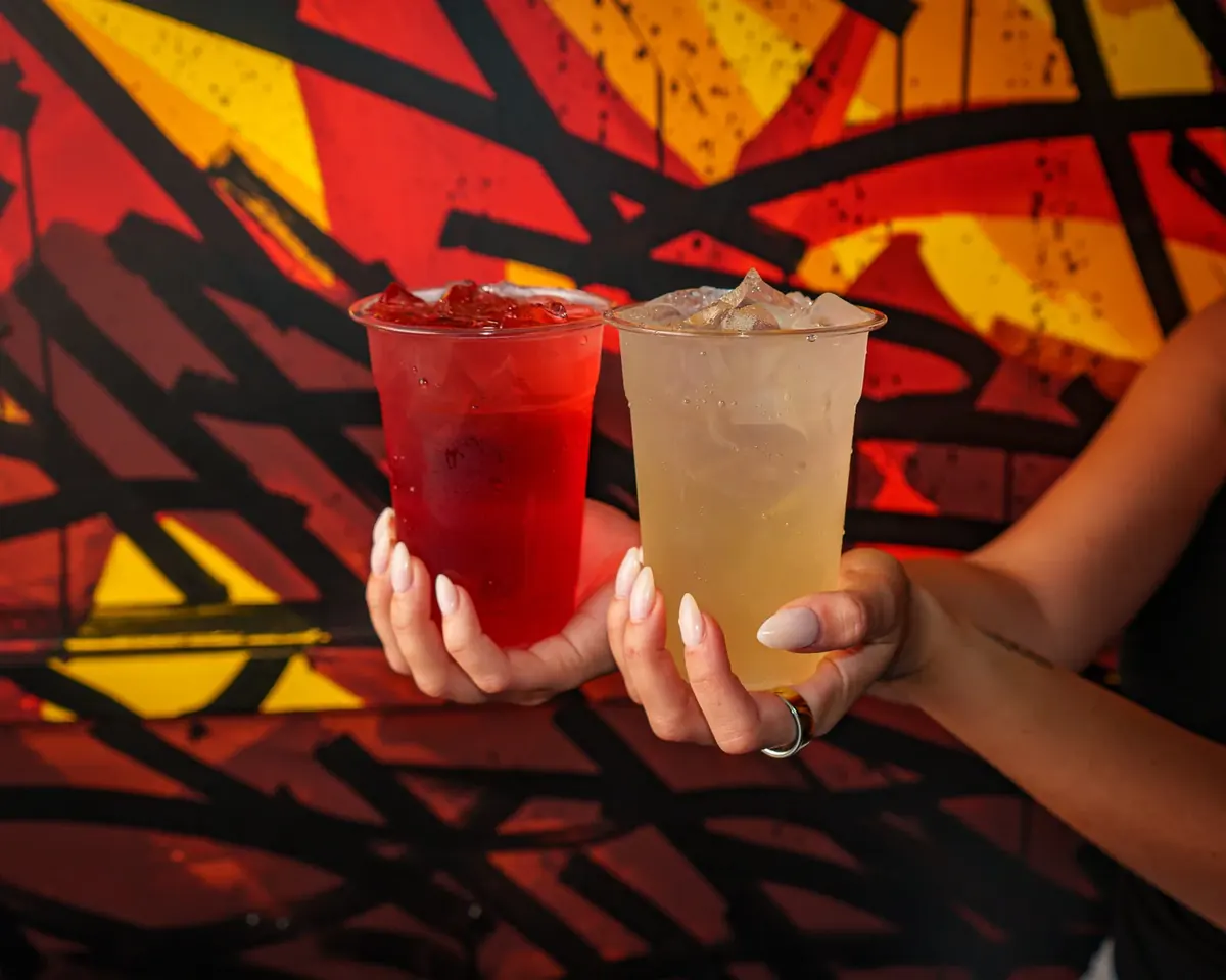 Two iced Mashed refreshers in front of the mural